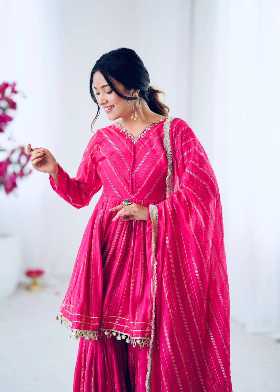 Woman in a bright pink traditional outfit with a white background