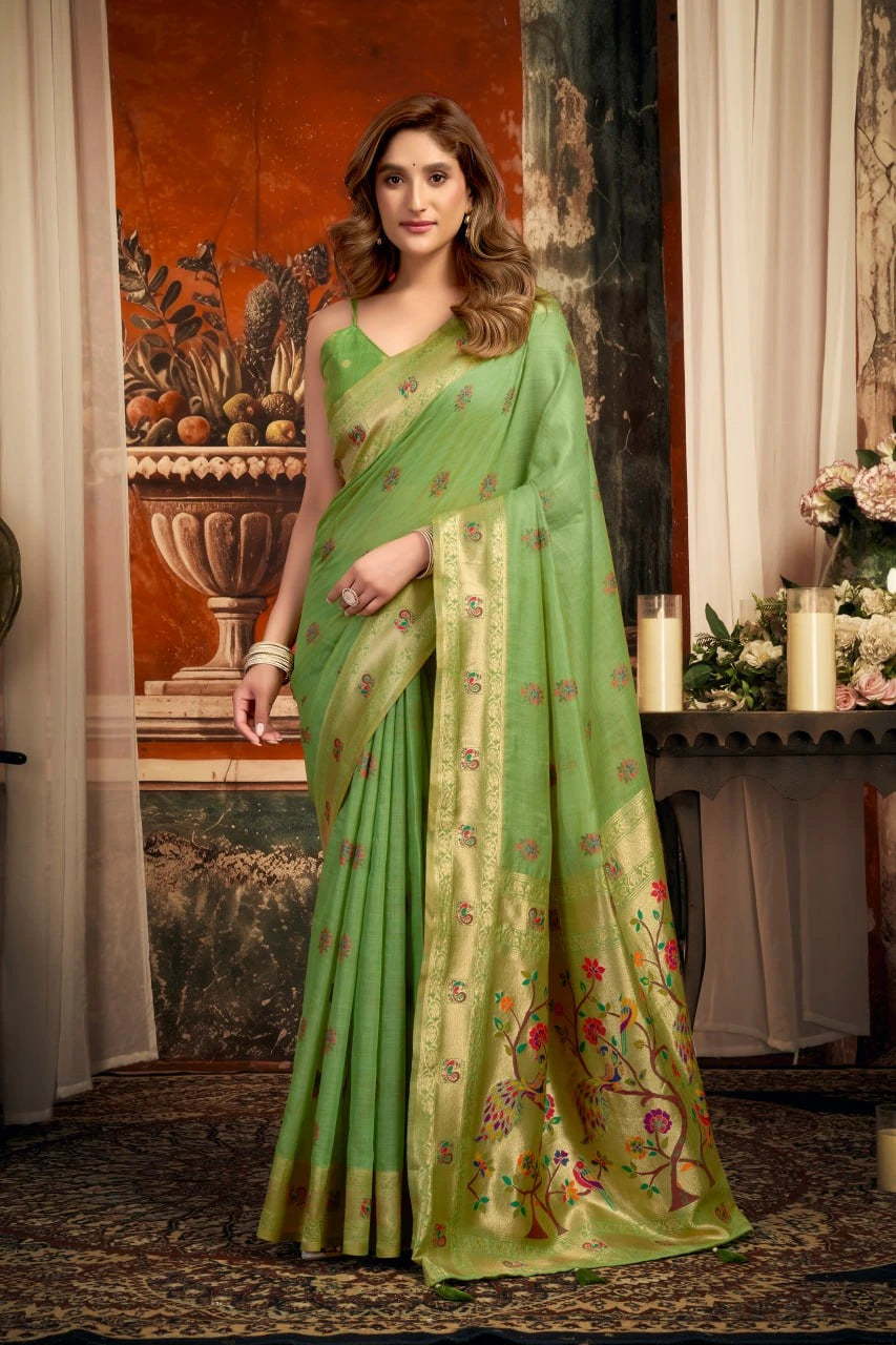 Woman wearing a green saree with a floral pattern in an indoor setting.