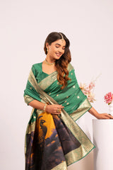 Woman wearing a green saree with a gold border on a white background