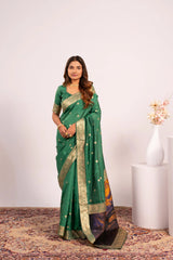 Woman wearing a green saree with gold border on a white background