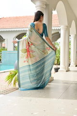 Woman in a floral saree standing on a porch with a pool and greenery in the background