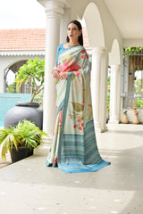 Woman wearing a floral saree standing on a porch with plants and architectural elements in the background.