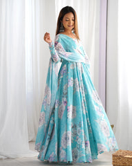 Woman wearing a light blue floral dress against a white curtain background