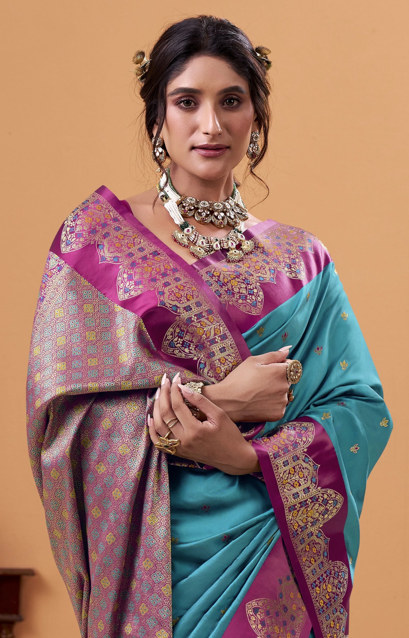 Woman wearing a traditional saree with a purple and blue design on a beige background