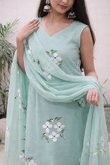 Woman wearing a light blue saree with floral patterns against a neutral background