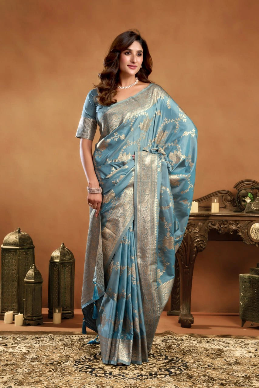 Woman wearing a blue and gray saree in a decorated room.