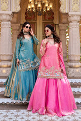 The flowing dupatta drapes elegantly along her side, enhancing the regal look.