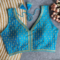 Blue embroidered blouse with matching headband on a textured surface