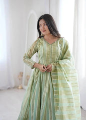 Close-up of mirror work V-neckline and gold striped jacquard fabric on pastel green suit
