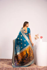 Woman wearing a blue saree with a white blouse, standing against a white background.