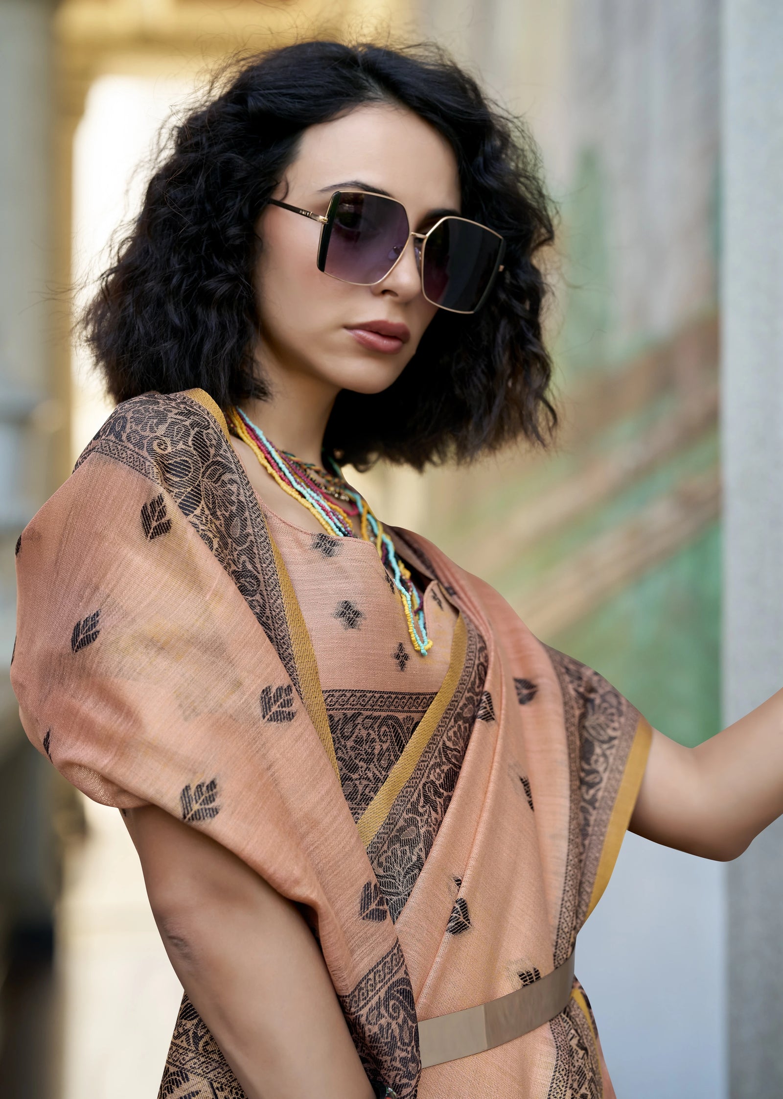 Woman wearing a patterned dress and sunglasses with a blurred background