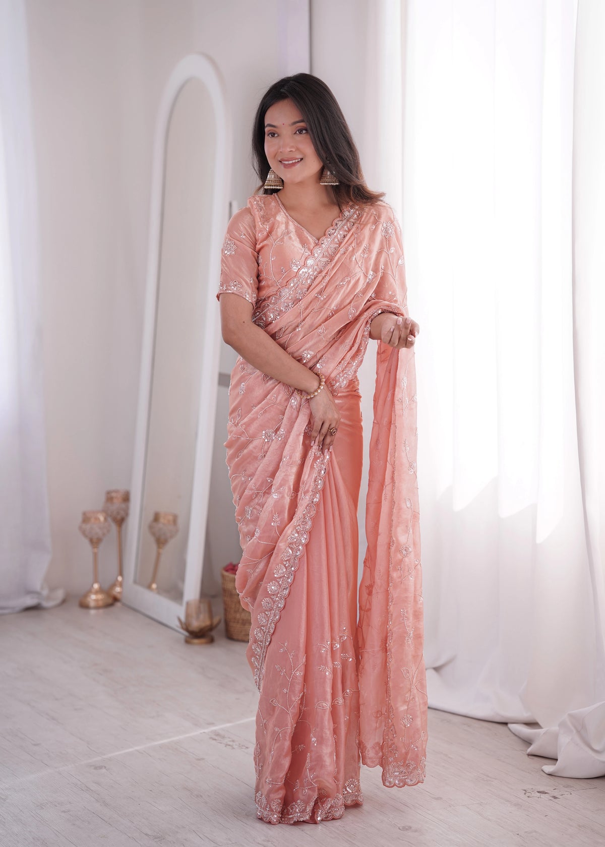 Woman wearing a pink saree with a white background