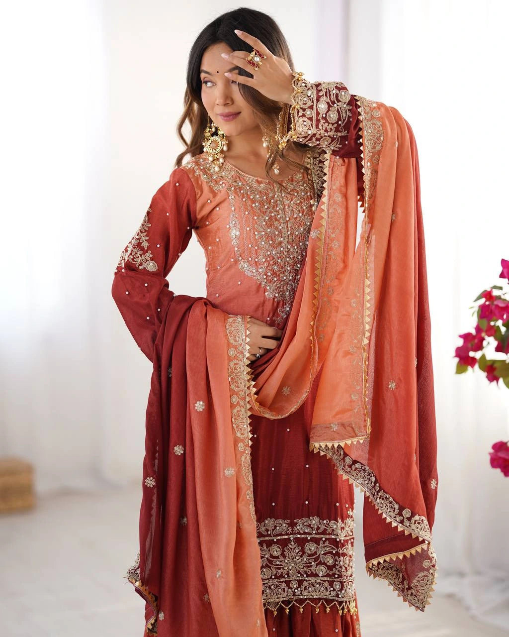 Woman wearing a traditional outfit with intricate designs in a bright setting