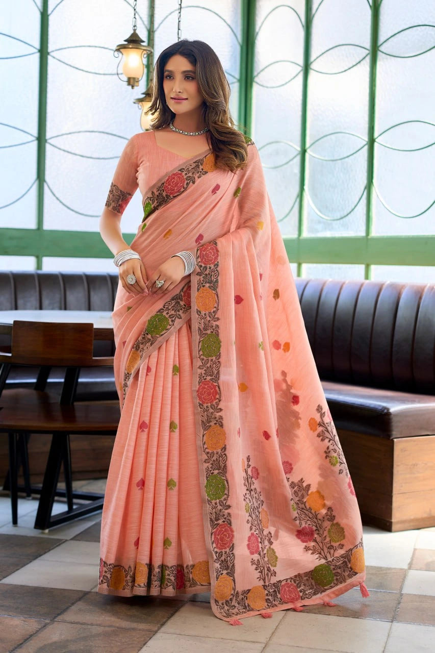 Woman wearing a peach saree with floral patterns in an indoor setting.