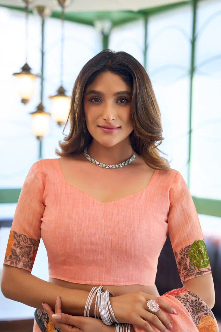 Woman wearing a peach blouse with floral arm designs indoors