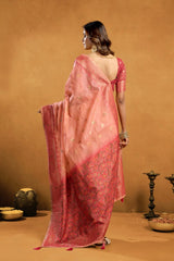 Woman wearing a pink saree with a gold background