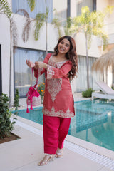 Woman in a pink traditional outfit standing by a poolside.