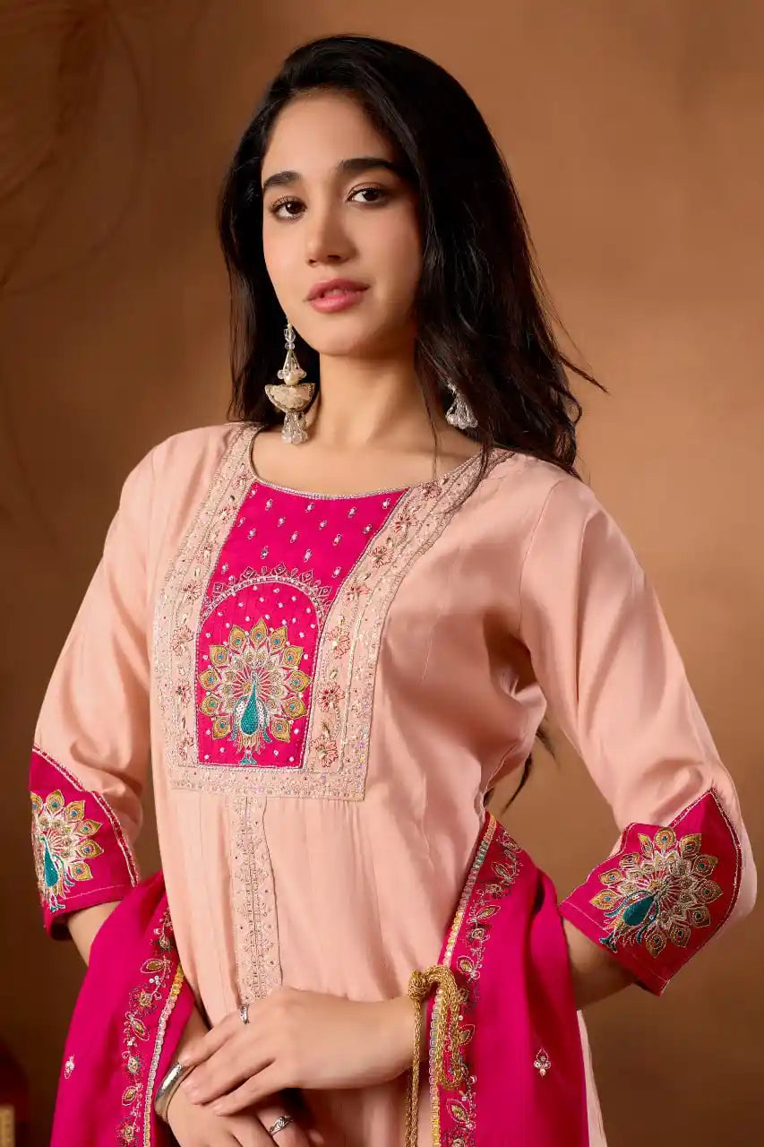 Woman wearing a traditional outfit with pink and red embroidery on a brown background
