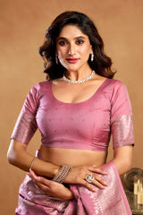 Woman wearing a pink saree with jewelry on a beige background