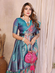 Woman wearing a traditional saree with a pink bag against a beige curtain background