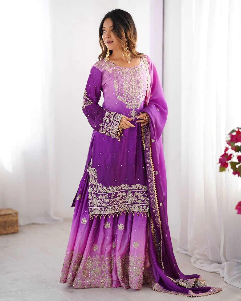 Woman wearing a purple traditional outfit with gold embroidery in a bright setting