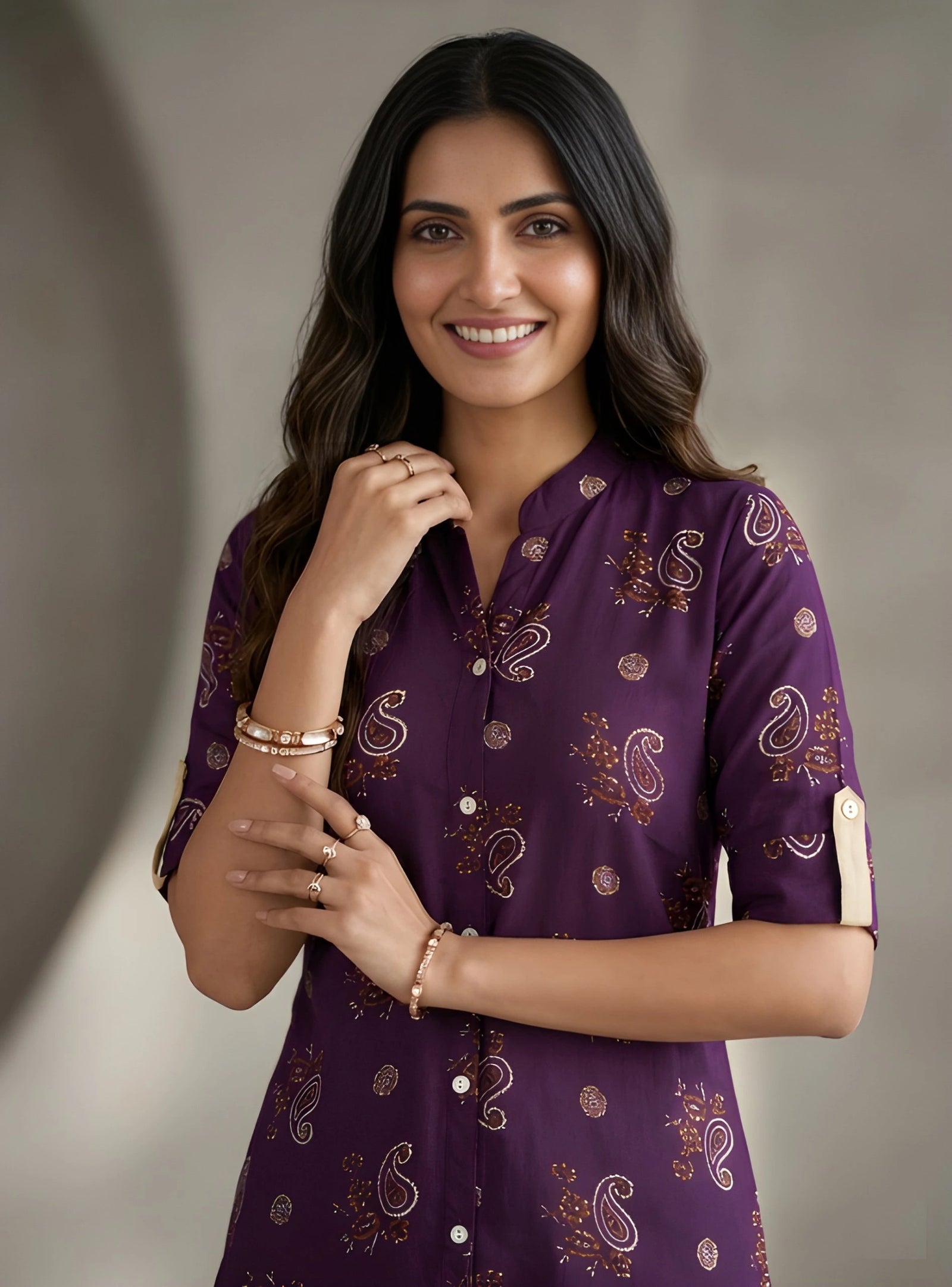 Woman wearing a purple patterned shirt against a neutral background