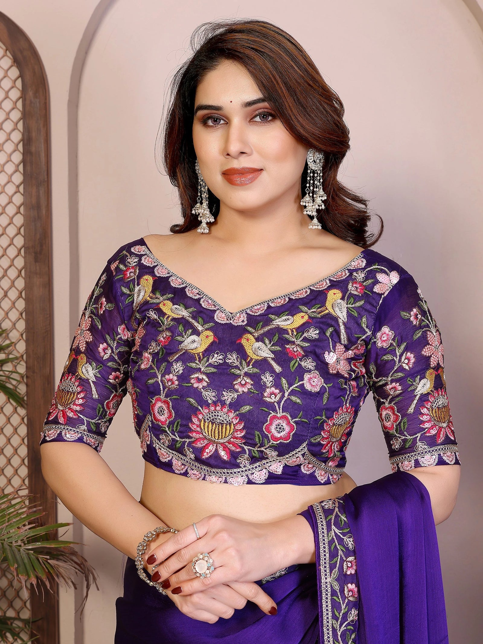 Woman wearing a purple embroidered saree with a floral pattern