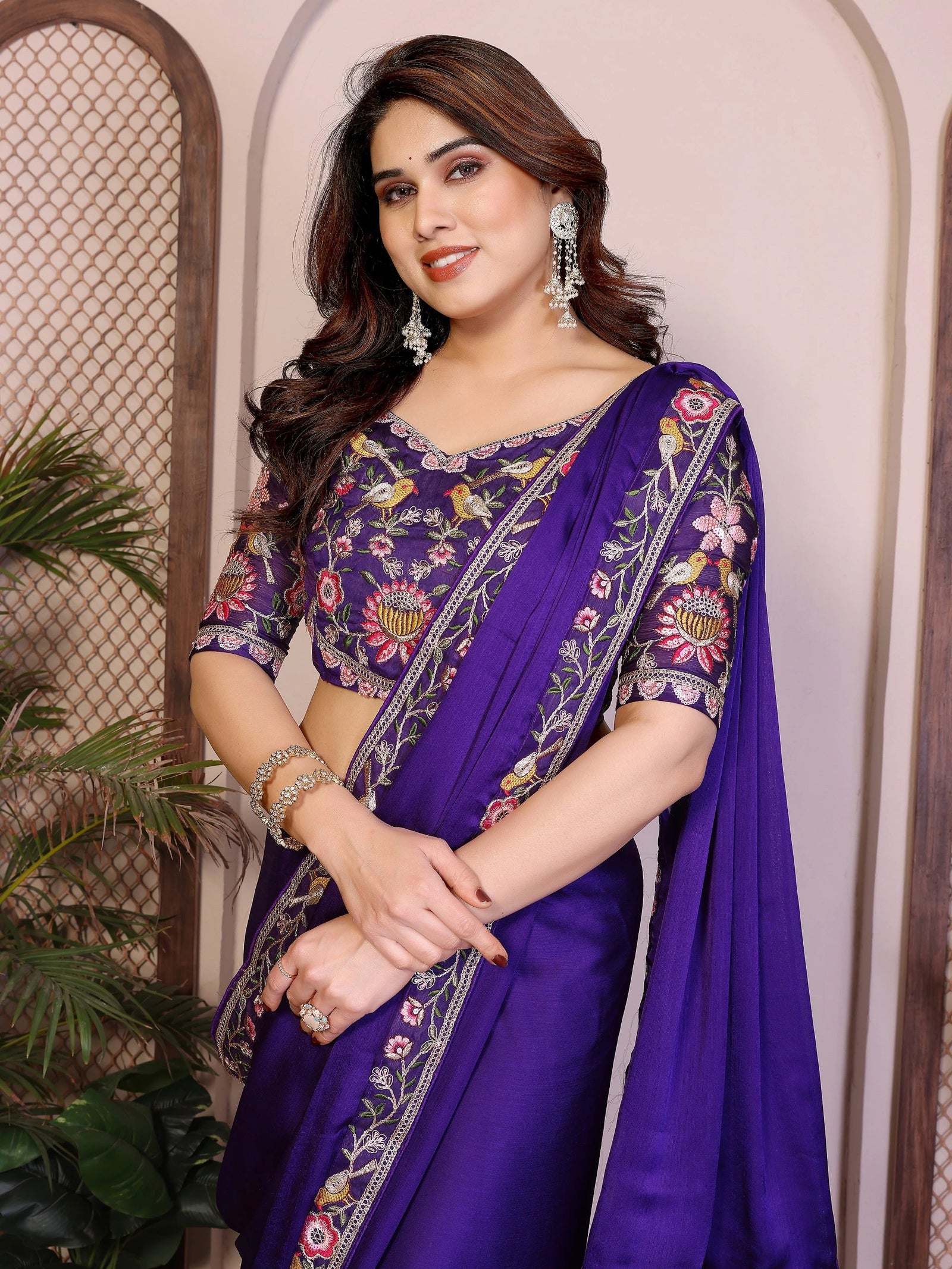 Woman wearing a purple embroidered saree with a floral pattern