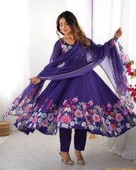 Woman in a purple floral outfit with a matching dupatta in a bright room.
