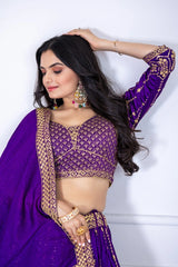 Woman wearing a purple traditional outfit with gold embroidery against a white background