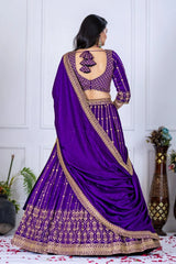 Purple saree with gold border worn by a model against a white paneled wall.