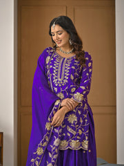 Woman wearing a purple embroidered traditional outfit indoors.