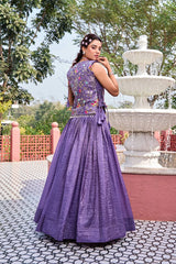 Woman in a purple dress standing in front of a fountain with trees in the background