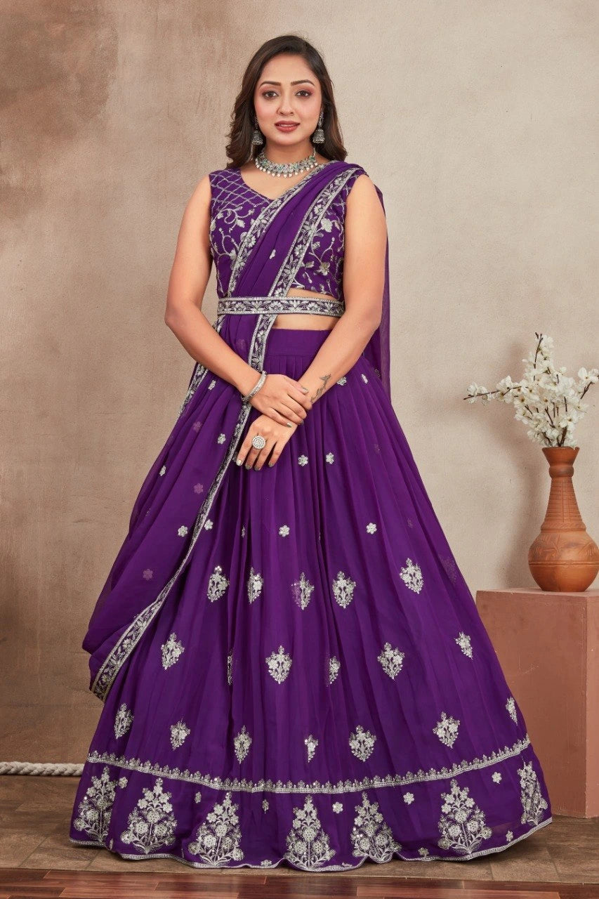 Woman wearing a purple embroidered saree with a neutral background