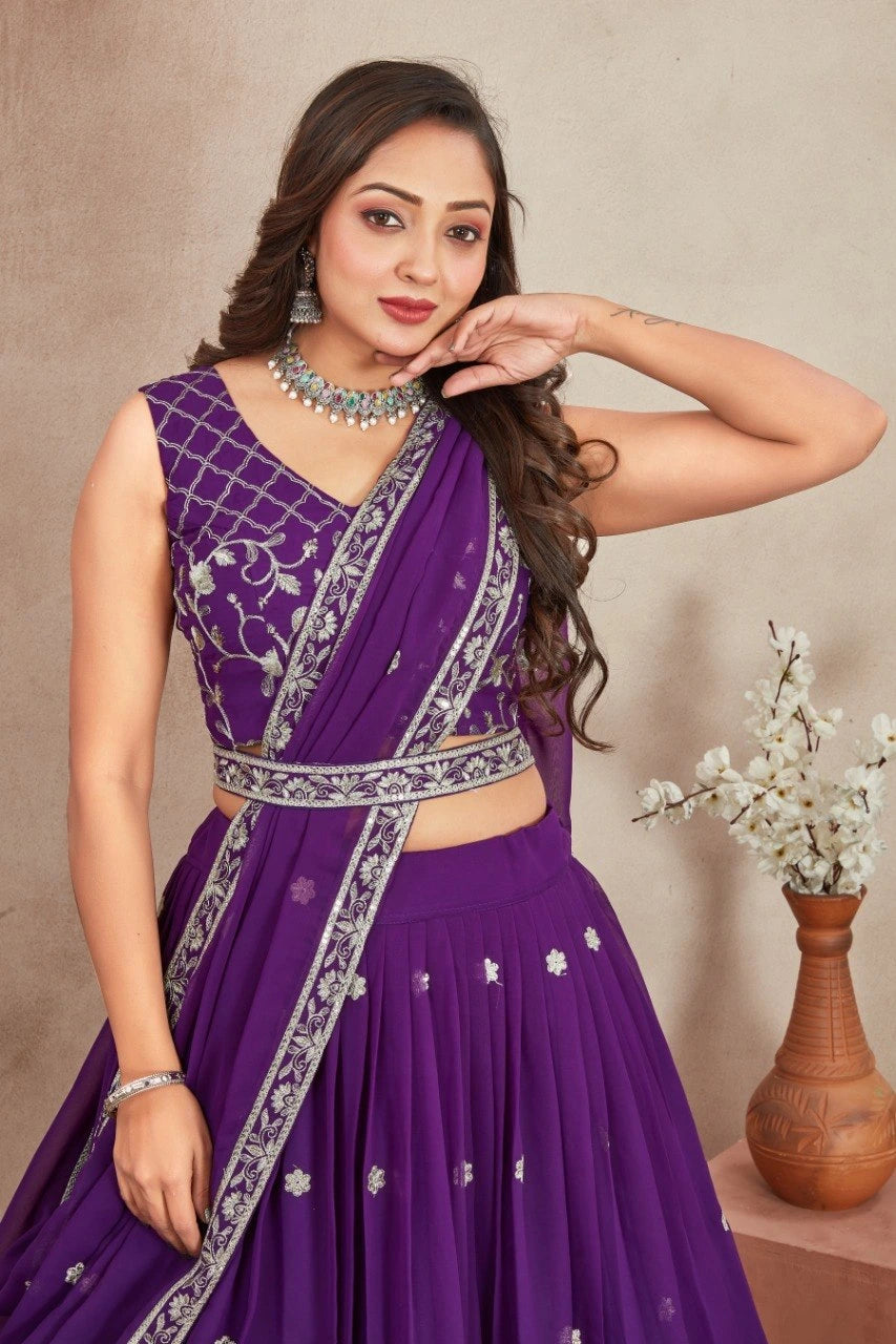 Woman wearing a purple saree with silver details against a beige background