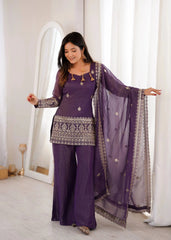 Woman in a purple traditional outfit with a matching dupatta in a well-lit room.