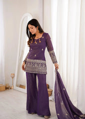 Woman in a purple traditional outfit holding a dupatta in a well-lit room.
