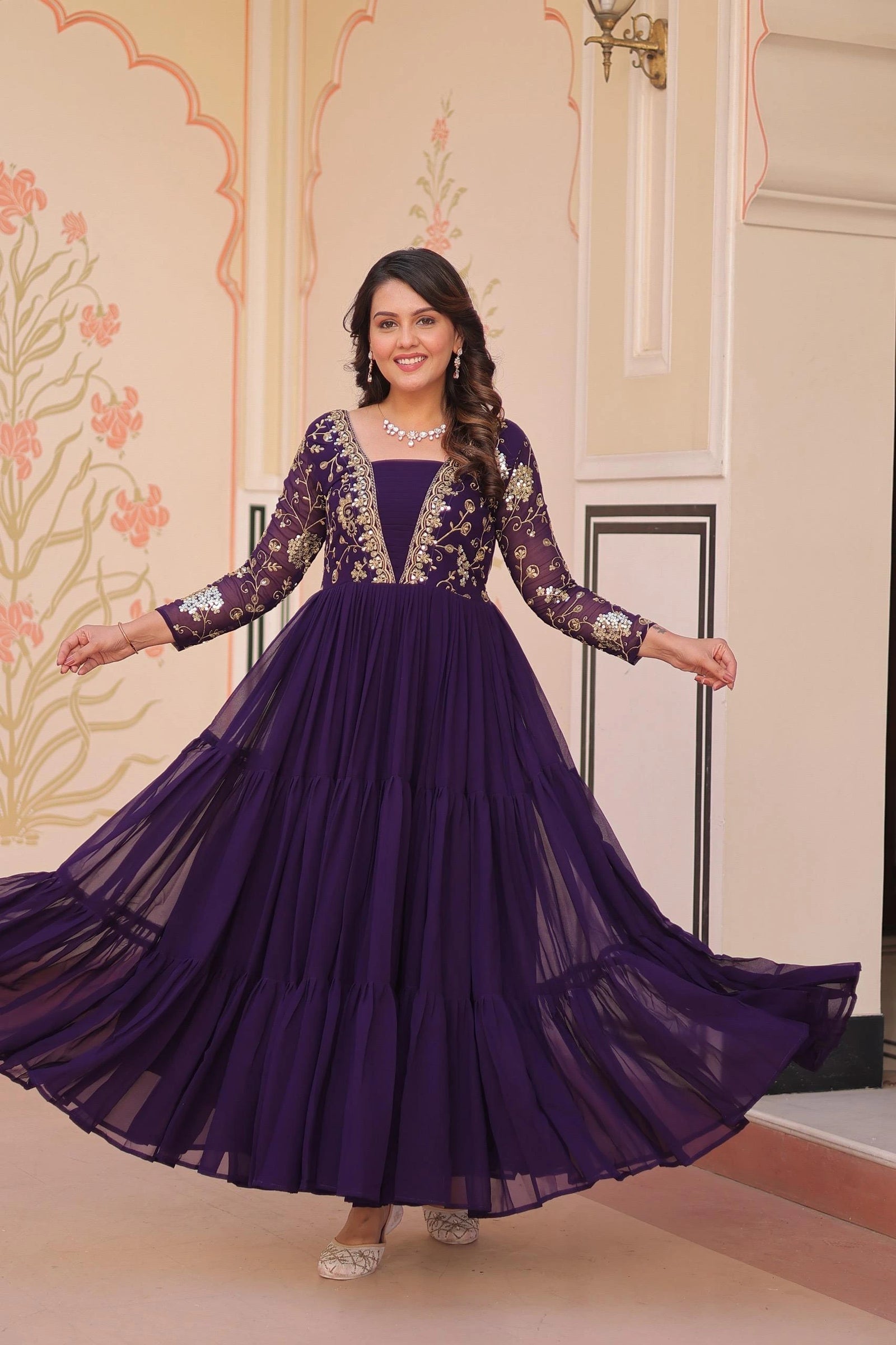 Woman in a purple gown with floral patterns in an indoor setting