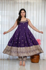 Woman wearing a purple anarkali suit with gold patterns in a well-lit room.