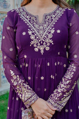 Purple dress with intricate white embroidery worn by a person.
