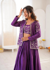 Woman wearing a purple traditional outfit with floral patterns in a minimalistic setting.