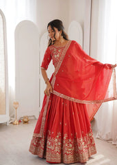 Woman in a red traditional outfit with gold embroidery in a minimalistic room.