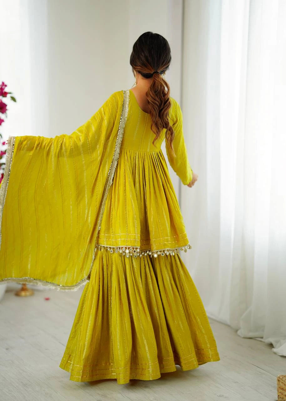 Woman wearing a yellow traditional outfit with a white curtain background