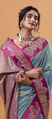 Woman wearing a traditional saree with intricate patterns on a beige background