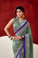 Woman wearing a green and purple saree against a red background