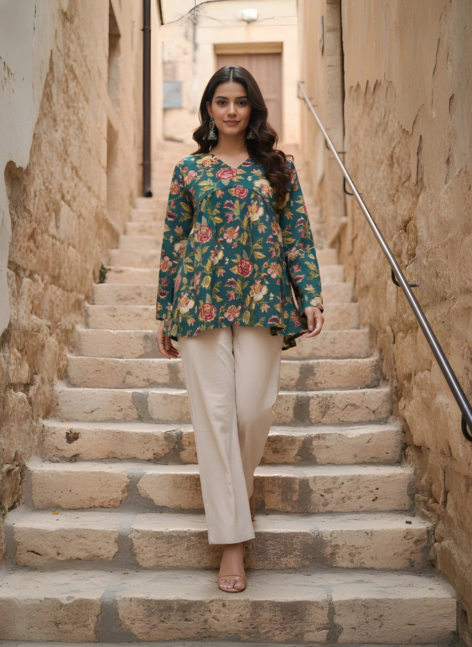 Woman in a floral top and beige pants standing on stone steps in an alleyway.