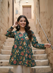 Woman in a floral dress standing on stone steps in an alleyway.