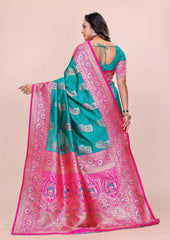 Woman wearing a green and pink saree with a beige background