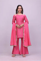 Woman wearing a pink traditional outfit with a matching dupatta on a light purple background