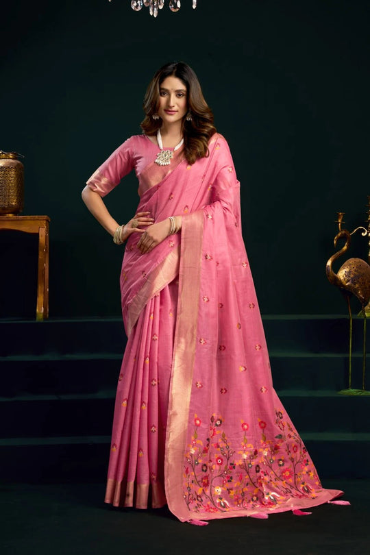 Woman in a pink saree with floral embroidery on a dark background